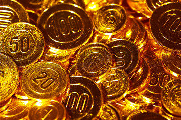 Golden coins piled in a heap of background