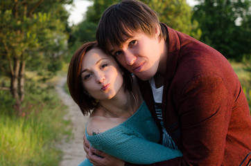 Fototapeta premium Happy couple on vacation. Lovers are laughing. Happy guy and girl. Lovers enjoy each other in the evening park. 