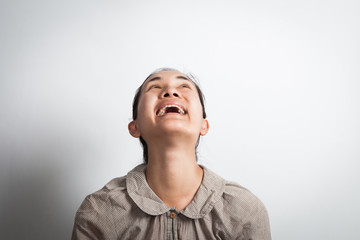 funny happy asian woman looking up - isolated over a gray background.