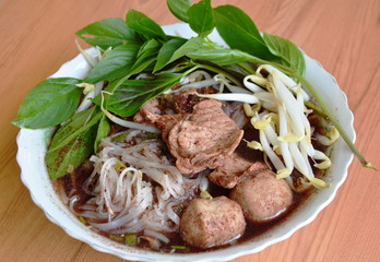 thin noodle with pork ball in brown soup on bowl