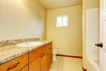 Bathroom interior with vanity cabinet, granite counter top, tile