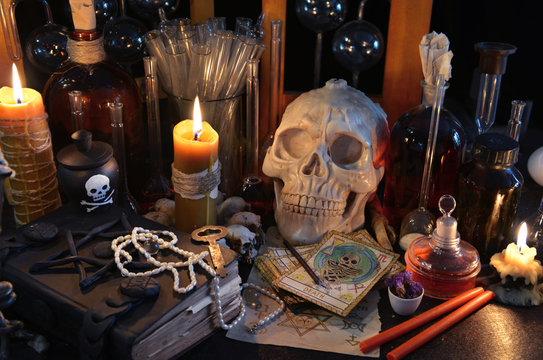 Magic still life with tarot cards, skull, book and burning candles