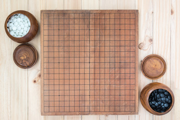 two wooden bowls with empty go game board