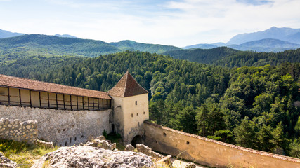 An inner court of medieval fortress surrounded by the carpathian mountains in a sunny day, Rasnov, Transylvania, Romania.