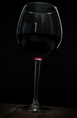 glass of red wine on black background.