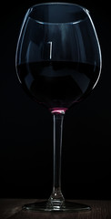 glass of red wine on black background.