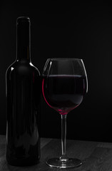 Elegant red wine glass and a wine bottle