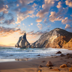 Fototapeta na wymiar Fantastic big rocks and stones on the ocean beach at sundown