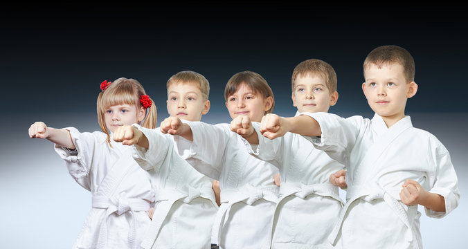 Five little athletes hit a punch on a gradient background