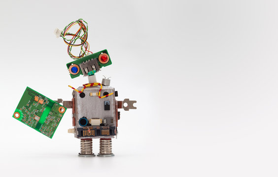 Robot with chip board. Computer accessories toy mechanism, funny head, electrical wire hairstyle, colorful blue red eyes. Copy space, gray background