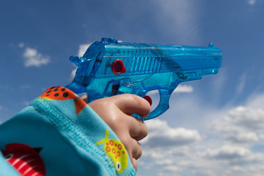 child hand holding toy gun / water pistol