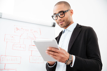 Happy young businessman using pc tablet in office