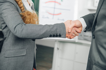 handshake of man and woman in suit