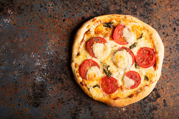 Pizza Margherita with red tomatoes and melted cheese