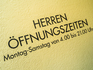 Fototapeta na wymiar Herren Öffnungszeiten. Schild an Herrentoilette