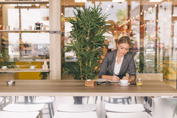 Fototapeta na wymiar Business woman on her coffee break sitting in cafe bar
