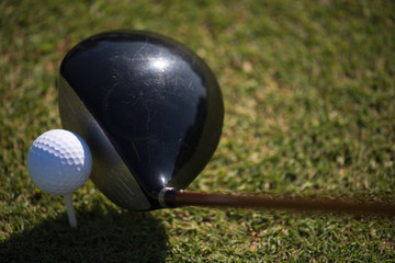 top view of golf club and ball in grass