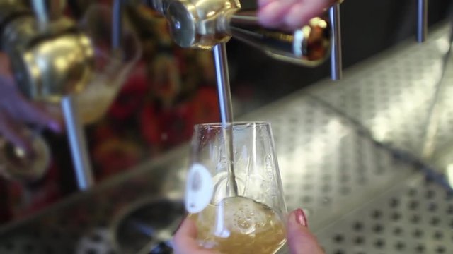 Female Hand Pouring Draft Beer From Tap. A beer tap is a valve, specifically a tap, for controlling the release of beer.