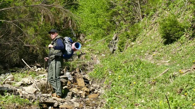 4K .Man  tourist   sit  and have rest near stream . Backpacker travel team