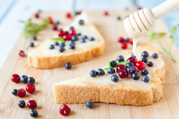 Sandwiches with cream honey, blueberries and cranberries