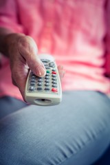 Senior woman changing tv channel