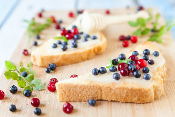 Sandwiches with cream honey, blueberries and cranberries