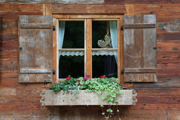 Fototapeta na wymiar Blumenkästen an einem alten Haus aus Holz