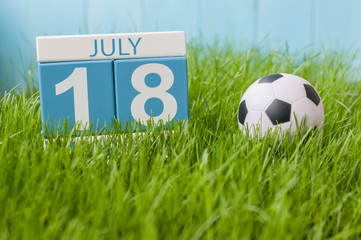 July 18th. Image of july 18 wooden color calendar on greengrass lawn background. Summer day, empty space for text