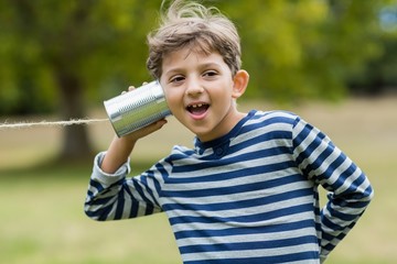 Boy listening through tin can phone