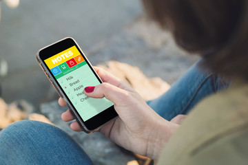 Woman checking shopping list on her smartphone