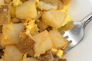 Close view of a breakfast meal with a fork on a plate.