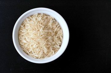 Basmati rice in the bowl on the black background