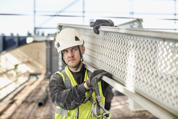 Man holding part of scaffolding at construction site 