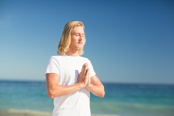 Fototapeta na wymiar Man performing yoga on beach