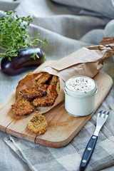 a portion of fried eggplant served with souce