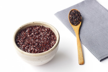 gruel (dark violet rice) in ceramic bow and wooden spoon isolated on white background