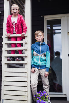 Portrait of brother and sister at porch