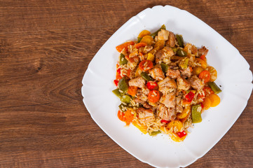 Rice with Vegetables and Meat in a plate on wooden table