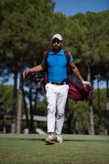 Obraz premium golf player walking and carrying bag