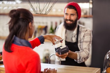 Seller taking payment with bank card reader and smartphone