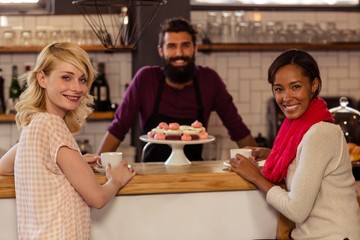 Customers drinking a coffee with the bartender