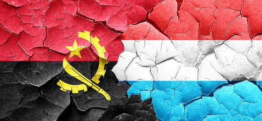 Angola flag with Luxembourg flag on a grunge cracked wall