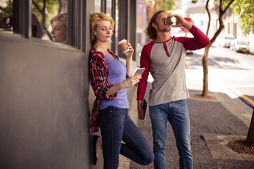 Customers using a smartphone and drinking coffee