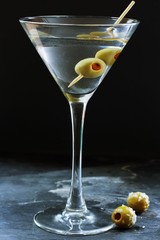 Martini cocktail in a martini glass with olives, selective focus