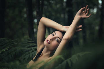 Woman posing among ferns