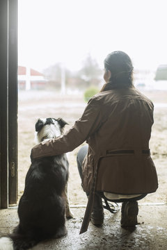 Woman crouching next  to border collie 