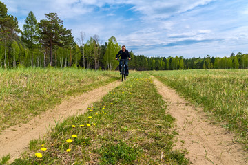 Obraz premium cyclist rides along a country road