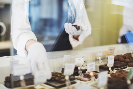 Person packing  pralines in store 