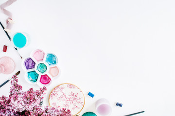 Workspace. Brushes, palette, bouquet of lilac isolated on white background. flat lay, overhead view, top view