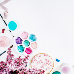 Workspace. Brushes, palette, bouquet of lilac isolated on white background. flat lay, overhead view, top view